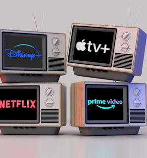 Four old-style television sets are stacked in two rows and each screen displays a different streaming service logo: Disney+, Apple TV+, Netflix, and Prime Video.